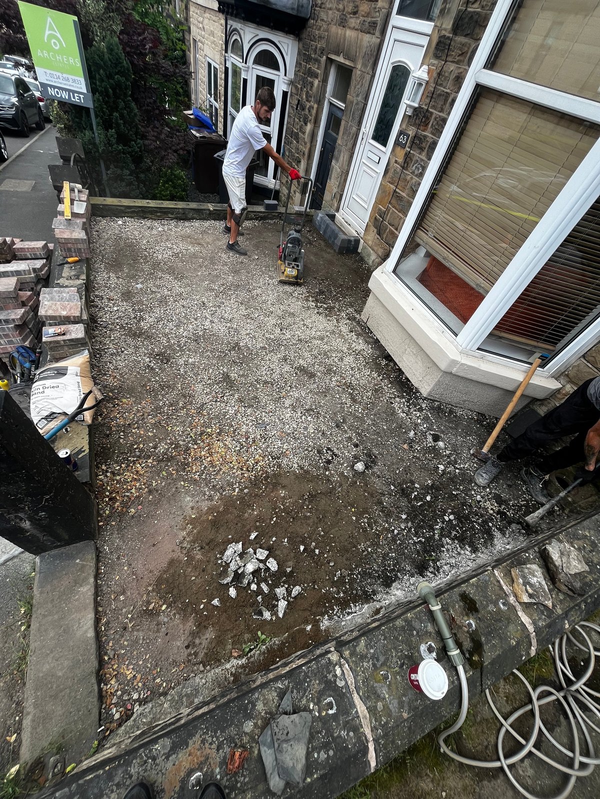 Construction worker working on gravel driveway before transformation